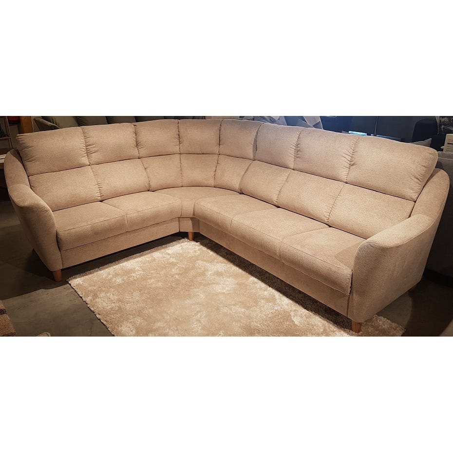 The Everest beige L-shaped sectional sofa with tufted cushions and wooden legs is featured on a light-colored rug in a living room setting.