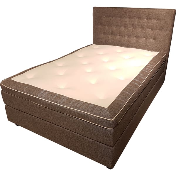 The Alpha 180 Continental is a brown upholstered bed featuring a high, tufted headboard and a cream-colored, cushioned mattress top, displayed against a white background.